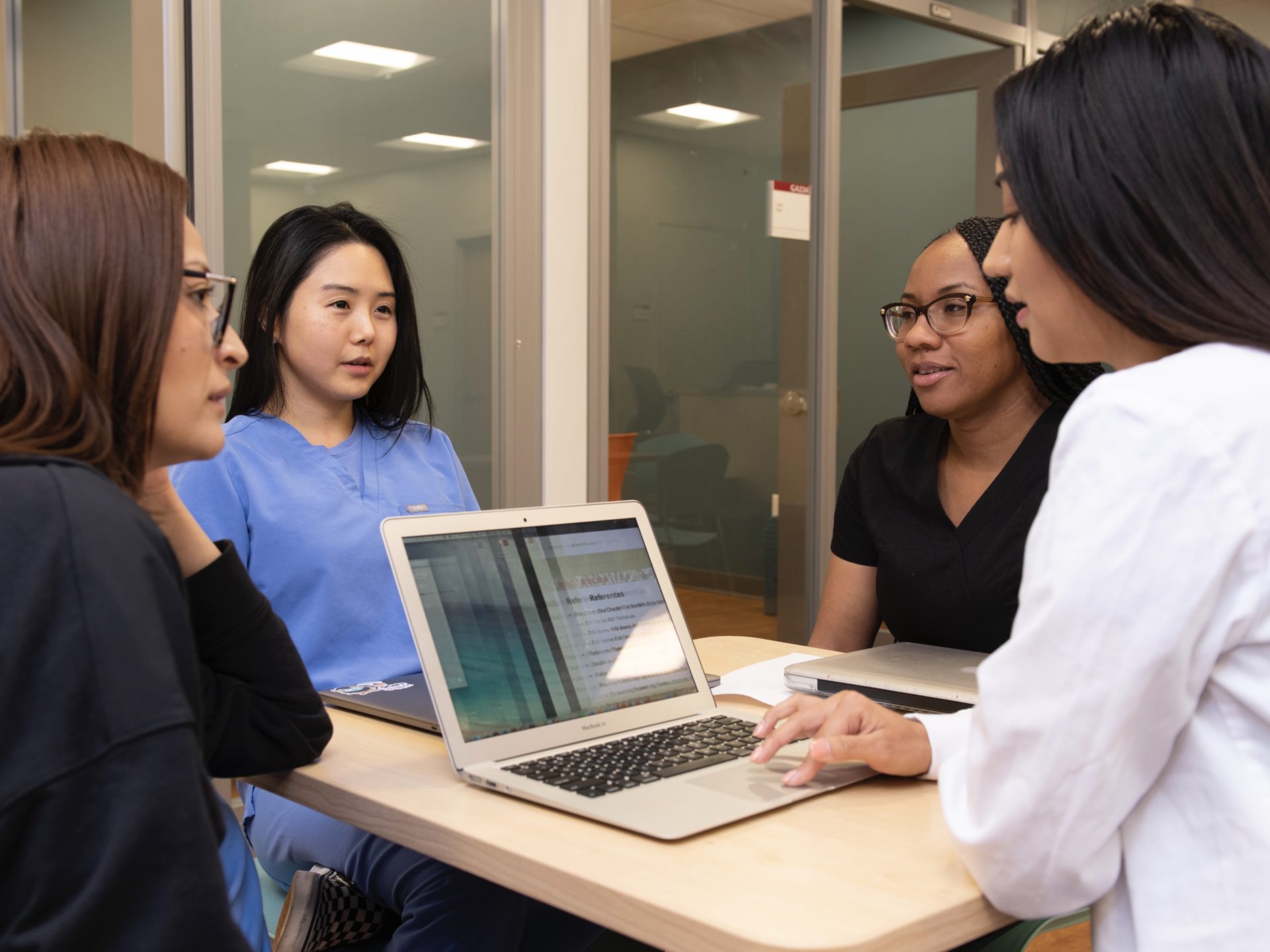 Four students collaborating around a table