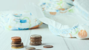 diapers in background with coins in foreground