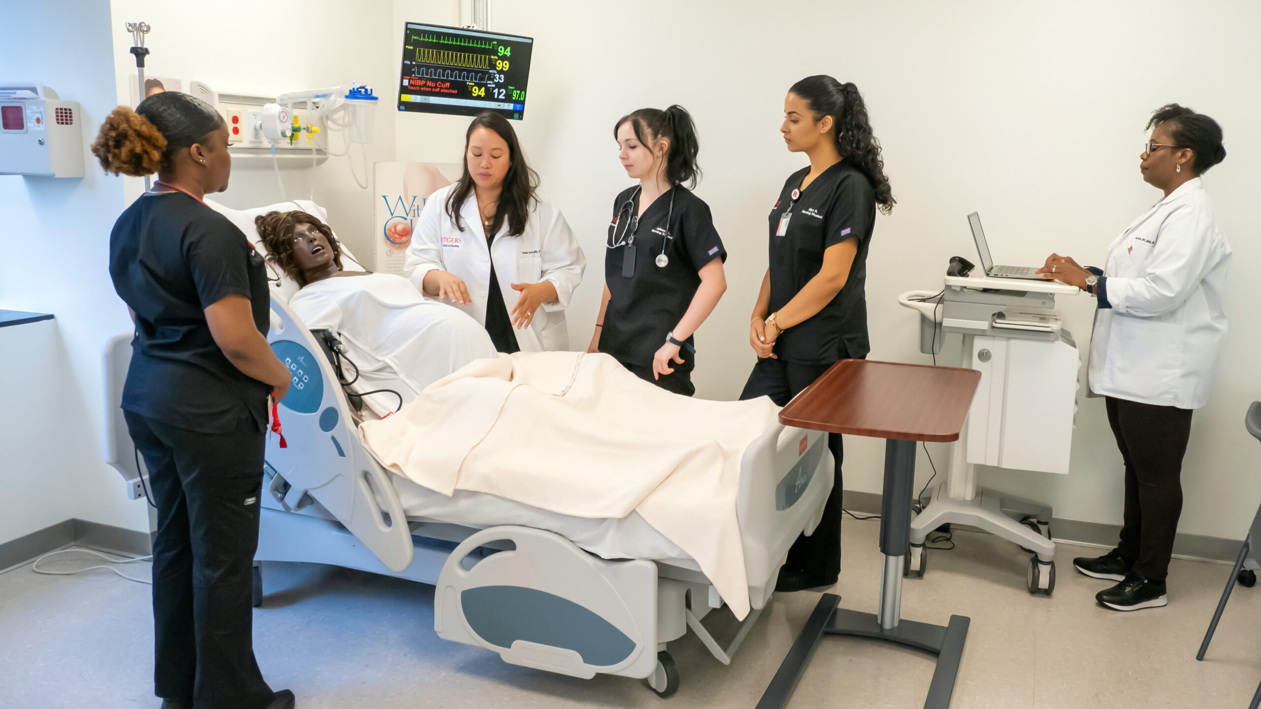 3 students and two instructors in the Maternity Sim room